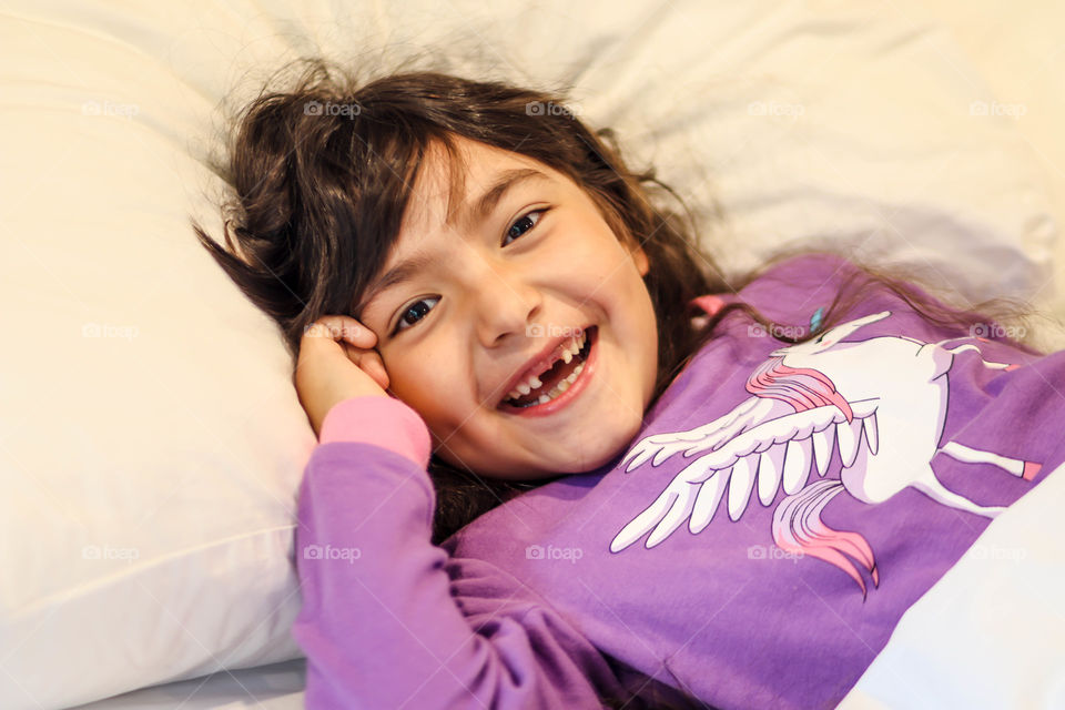 Lovely morning: cute little girl in pajamas with unicorn