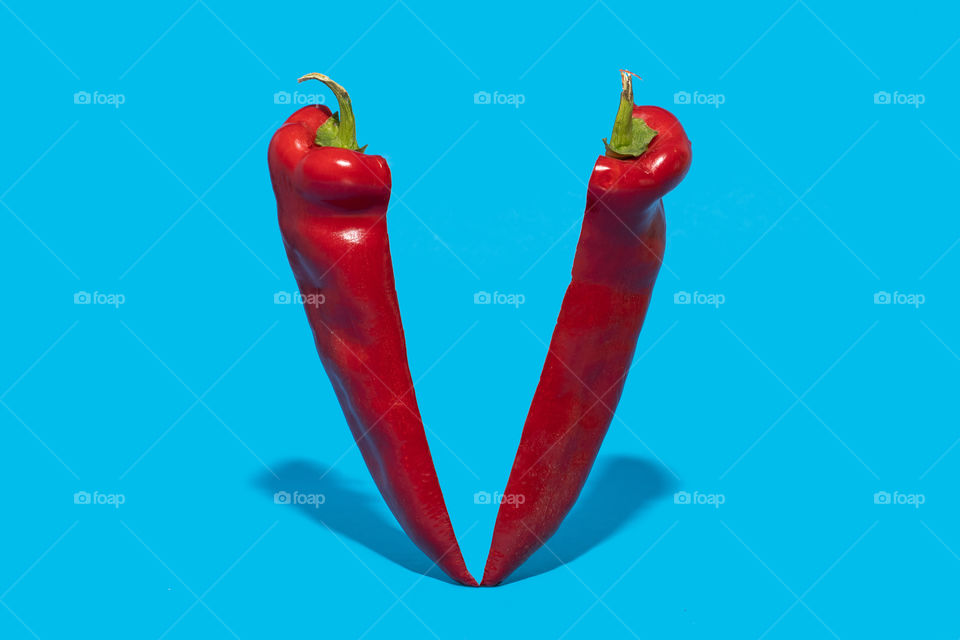 Chilli pepper sliced on half on blue background