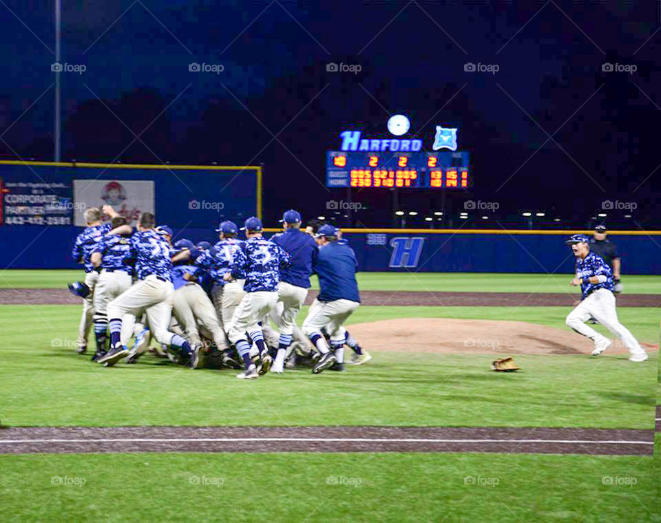 college baseball dogpile. players rush the field after divisional win to create giant dogpile