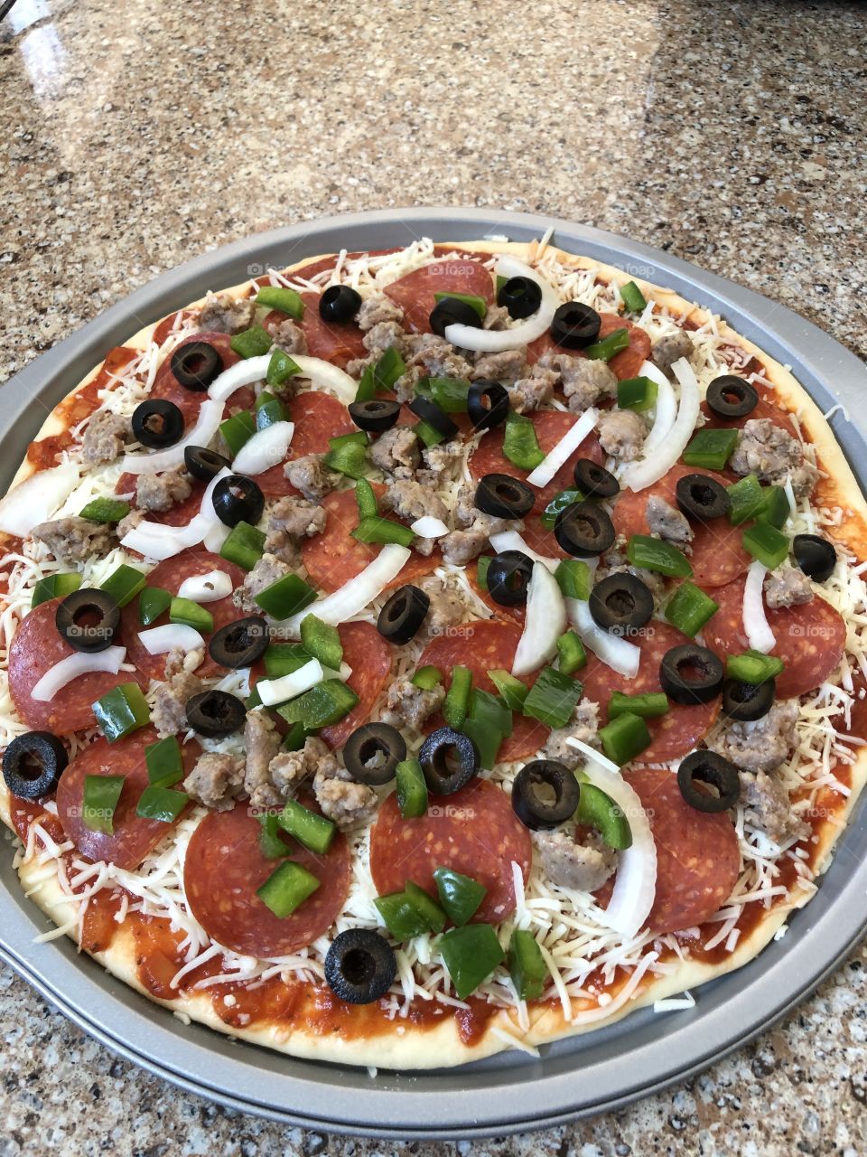 A delicious homemade meat lovers pizza ready to be baked.