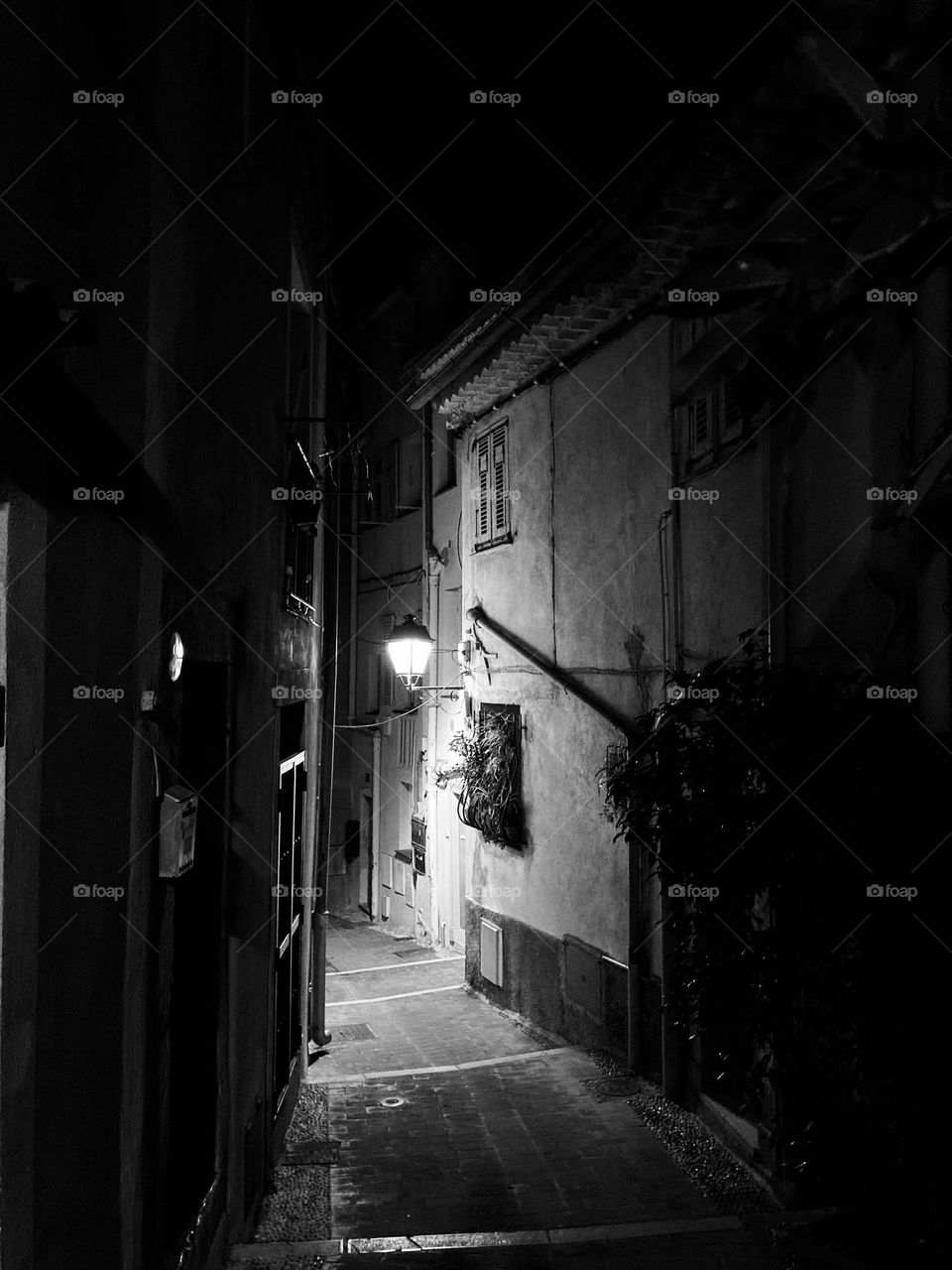 A solo streetlamp guides our way through the old town of Menton, France.