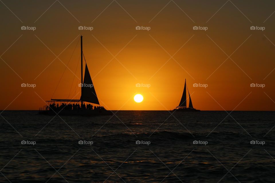 two sailing boats navigating at sunset