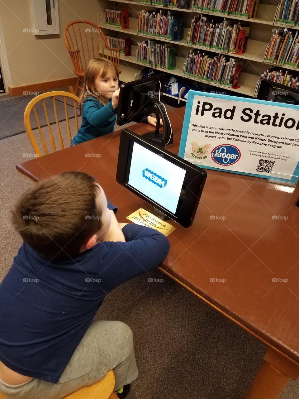 Children sitting in front of computer in library