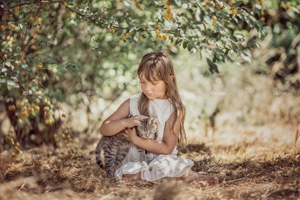 Children playing with kitten in a garden