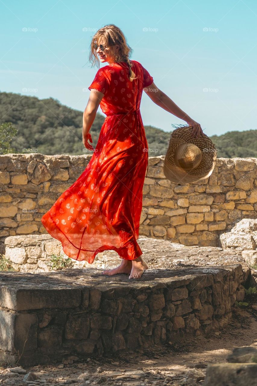 Young woman in red dress dancing outdoors