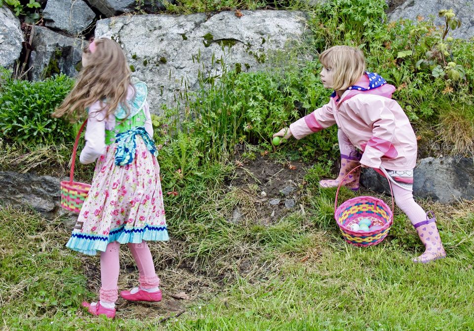 Girls search for candy at Easter egg hunt 