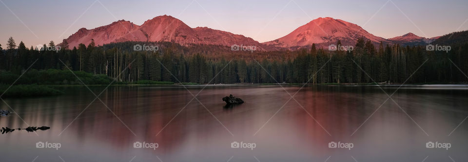 The kiosk rags in Mount Lassen in the sunset by Manzanita lake long exposure photo with soft water