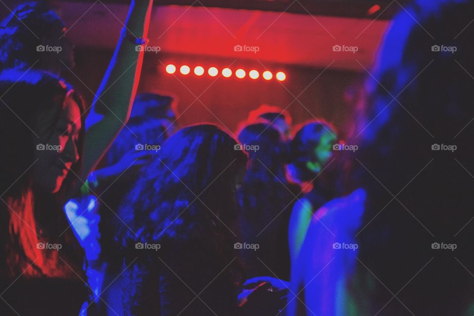 Vibrant shot of people dancing in a full room of bright lights