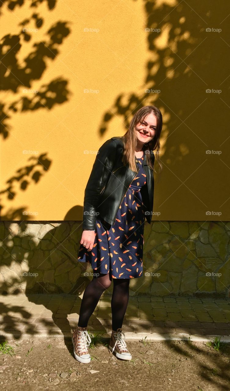 Happy smiling girl at yellow wall 