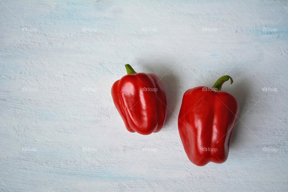 two red peppers on a white background