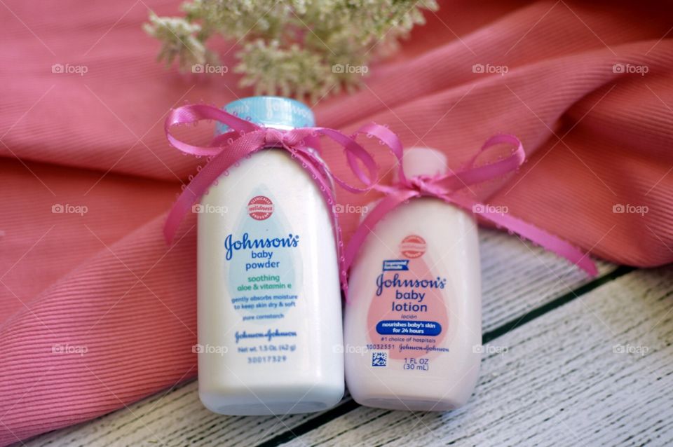 Johnson and Johnson baby lotion and powder with a pink ribbon and white background