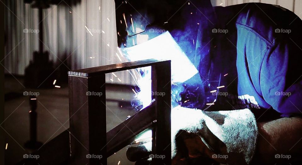 A construction worker welding and metal working. 