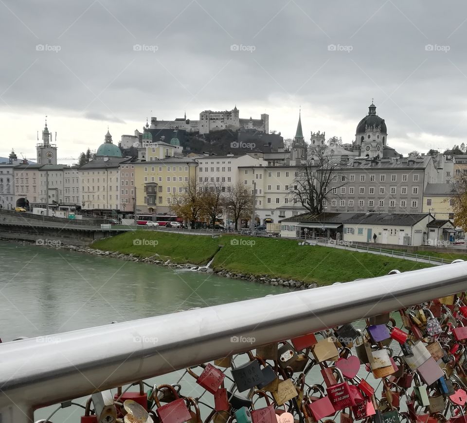 This photo was taken on a windy day in Salzburg, Austria. From the lover's bridge over the Salzach river you can see the Hohensalzburg castle and the old town.
