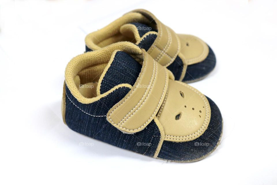 Photo of a pair of children's shoes made of artificial leather. This photo is on a white background