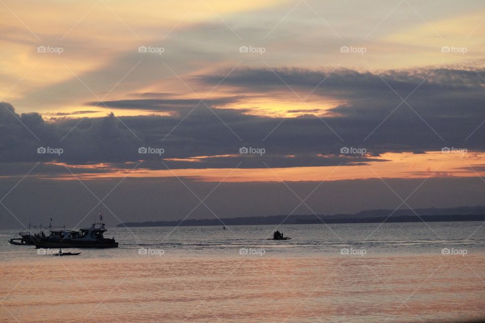 Scenic view of beach against sky at sunset 