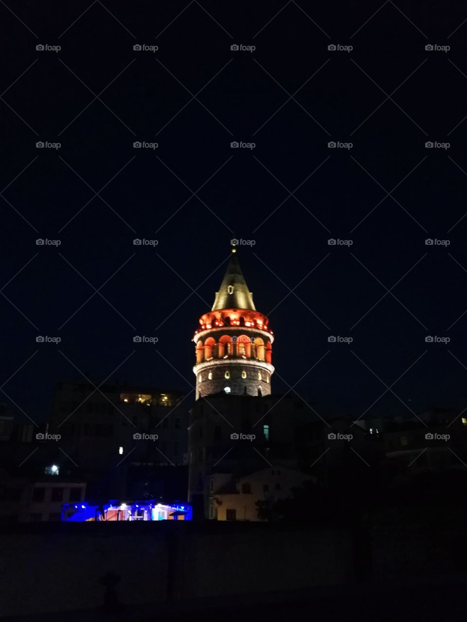 Red iluminated the old Galata tower night view from the terrace of other house.