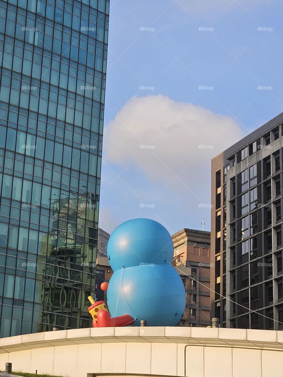 Little blue cute monster appears on the city rooftop