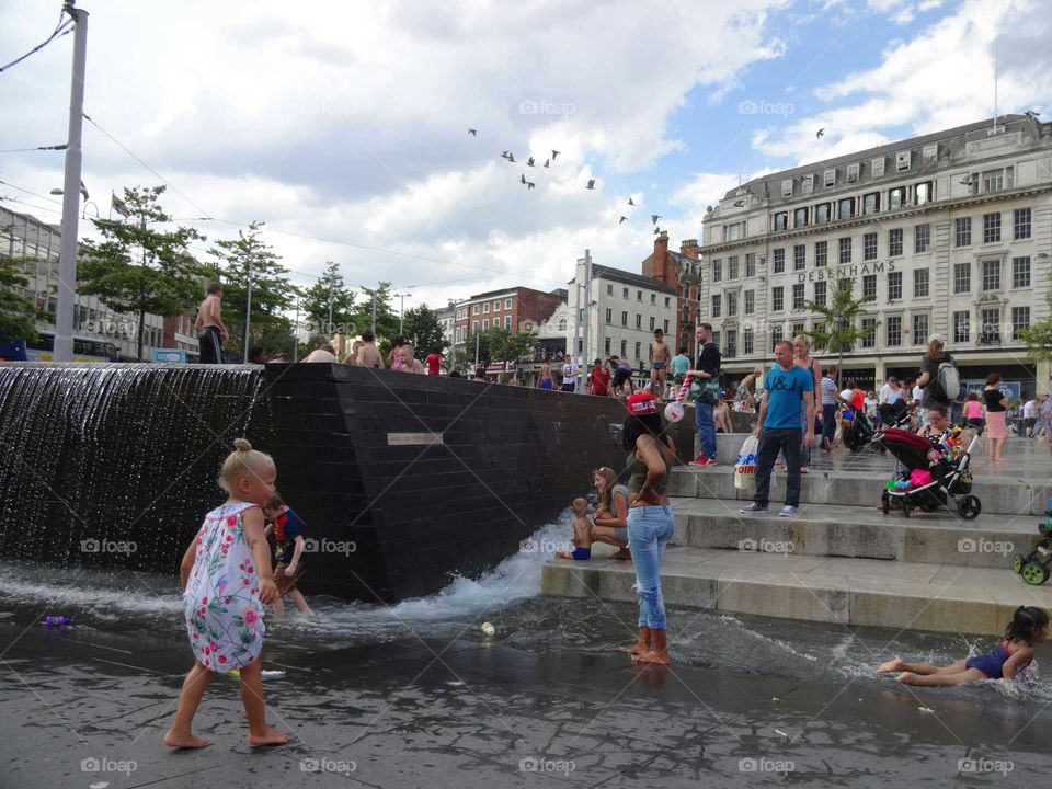 People cooling off in the fountains at Old Market Square in Nottingham, England