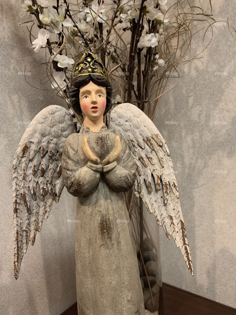 Angel with wings statue displayed in front of white flowers and twigs for the Christmas holiday season. USA, America 