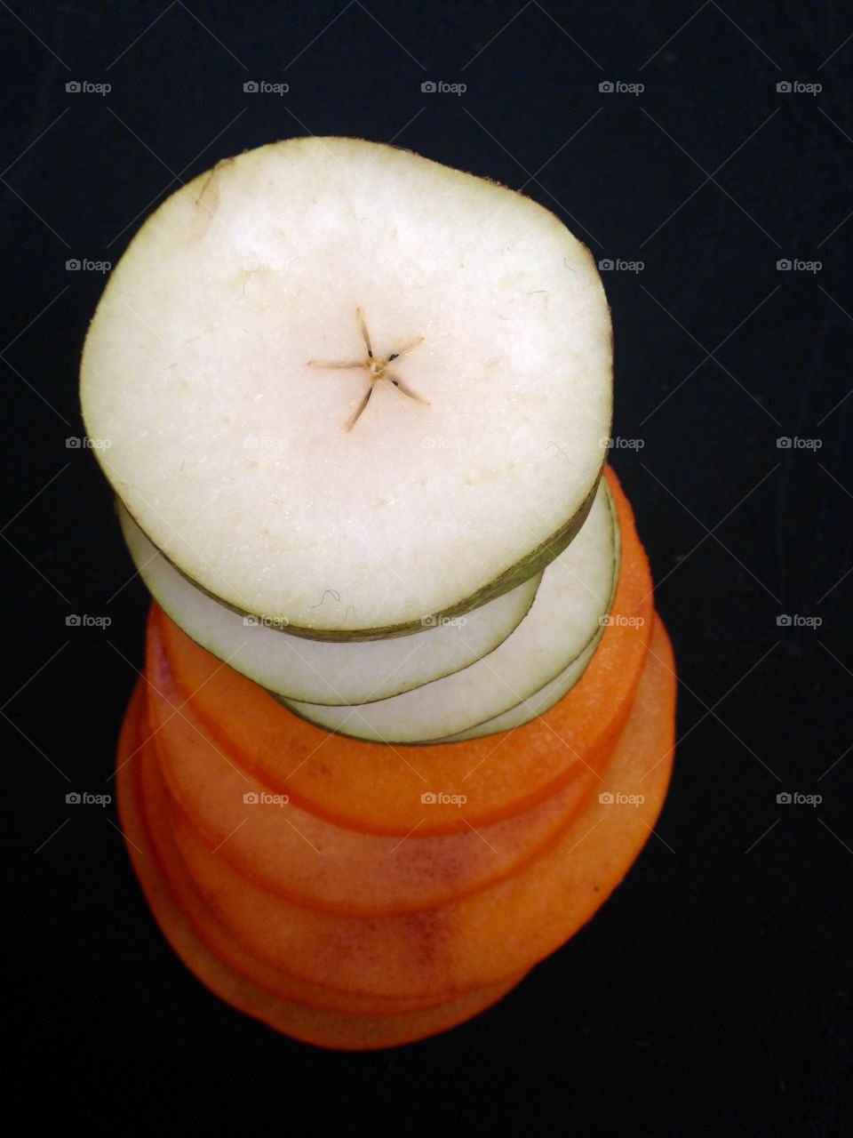 Pear and persimmon slices on black 