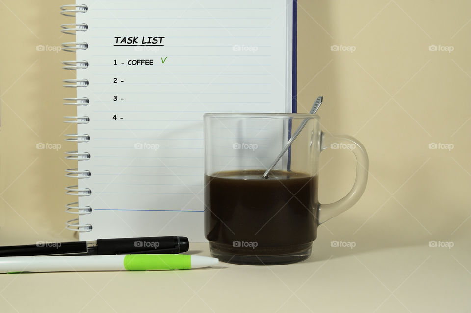 Task list with coffee first and a cup of black coffee.