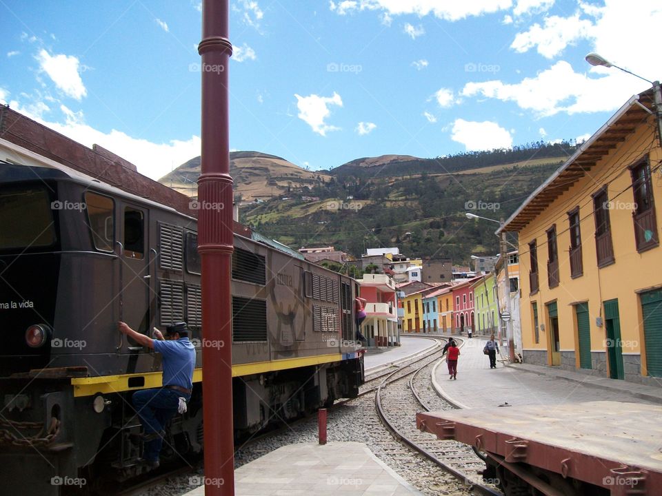 A conductor getting ready to ride the train in the quaint town of Alausi Ecuador 