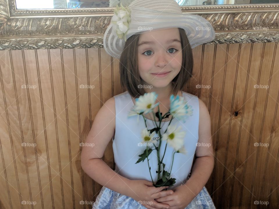 Easter Sunday doll dressed to impress and ready for church. She is flawlessly beautiful with an elegant blue summer dress holding a bundle of Daisy's