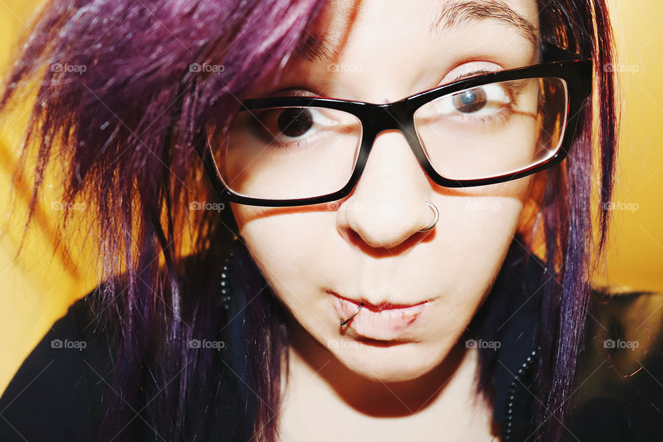 Purple hair glasses young woman with piercings and brown eyes 