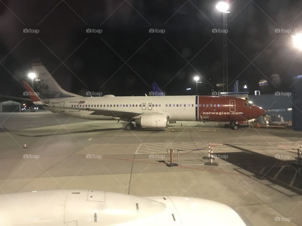 A Norwegian 737-800 (738) parked at gate in Flesland Airport, Bergen (IACO: ENBR) ID: BGO. The Norwegian 737s has a red nose tip, and custom (different) liveries on all planes where the logo would be.
