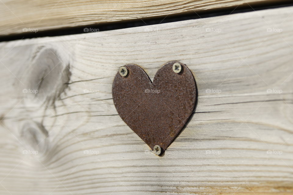 Heart shape metal on wooden plank