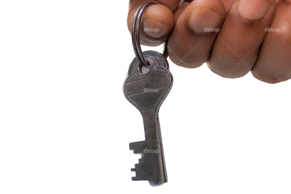 Close up of bunch of antique two iron metal keys attached on a ring, a real estate selling person holding it on isolated white background. Selective focus with copy space. Safe secure business concept