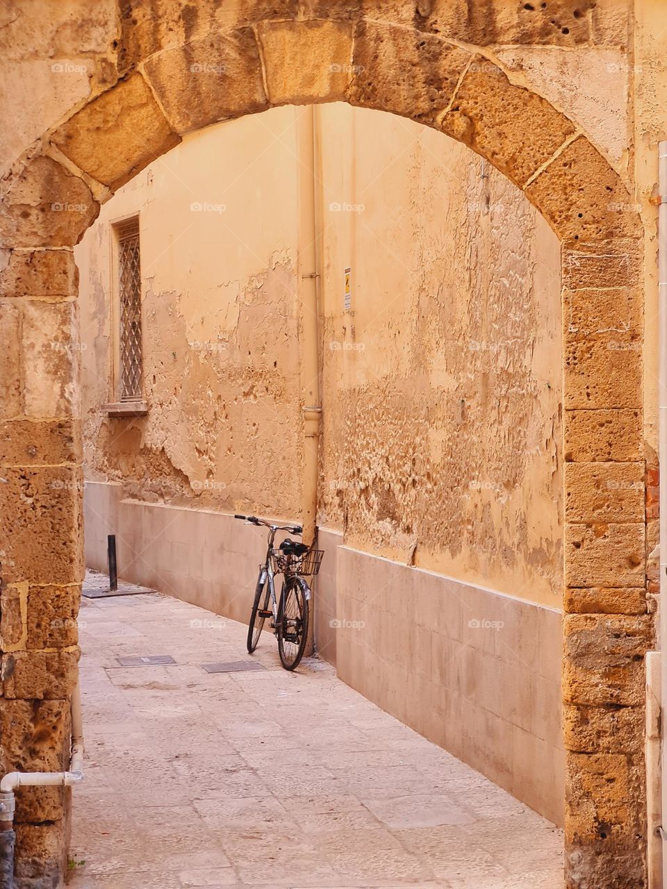 bicycle parked under an arch in the alleys of old Bari