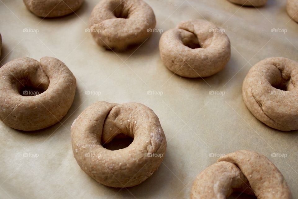 Angled overhead view of sourdough spelt and whole wheat dough for bagels on parchment paper