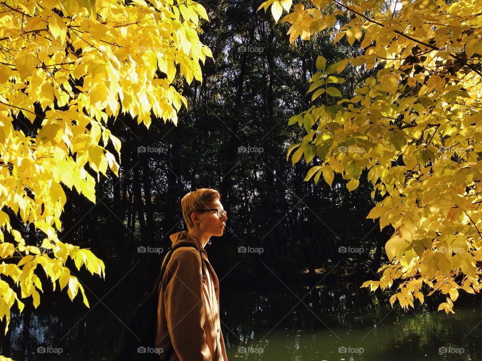 Morning light. Man exploring autumn park 