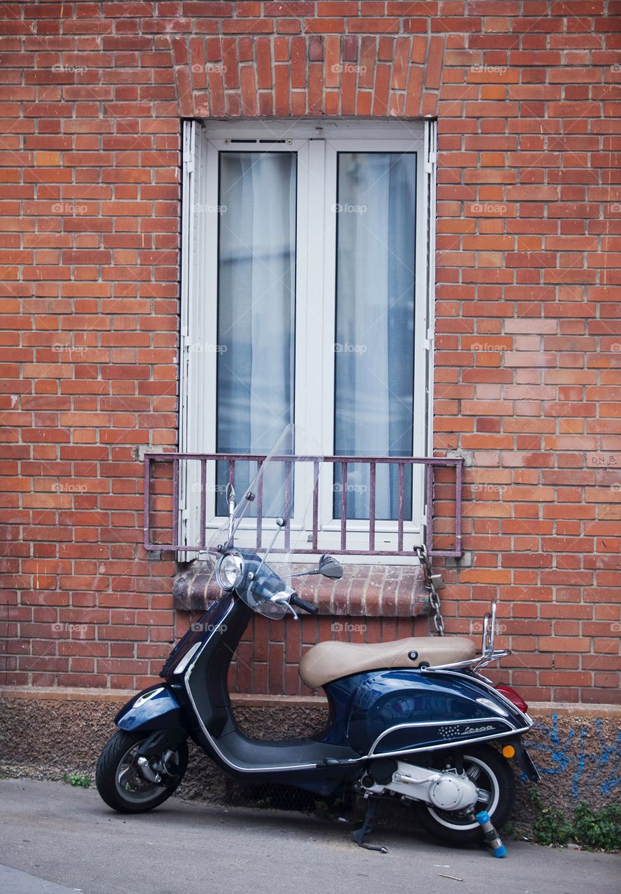 Scooter parked above a window