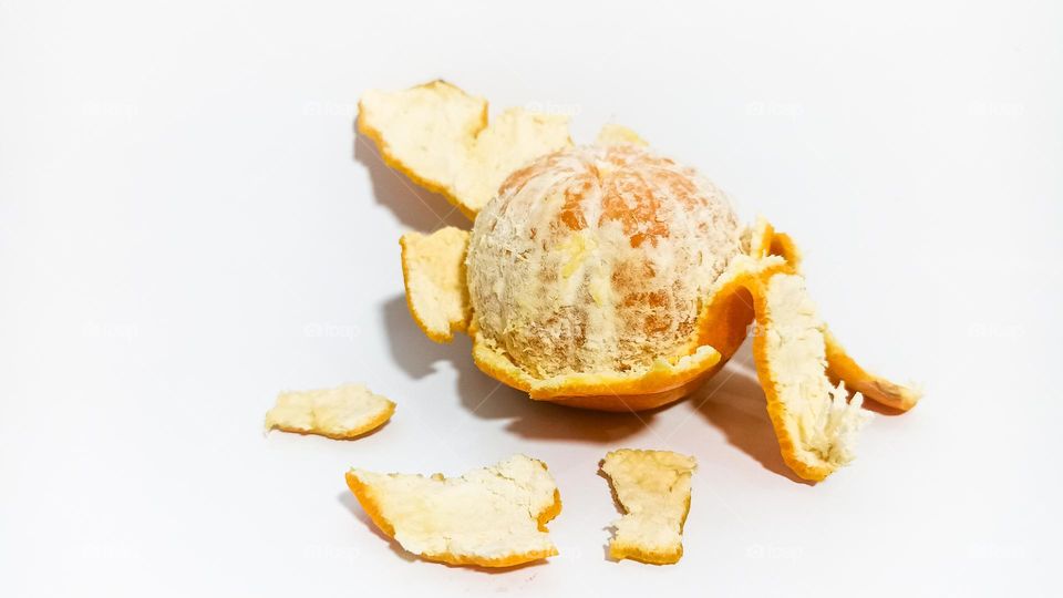 Peeled orange on isolated white background in eye level view