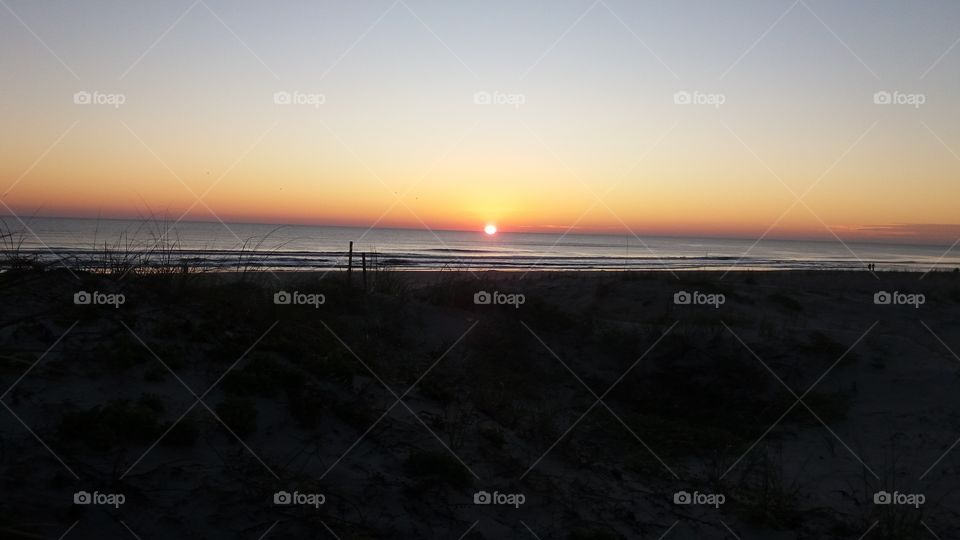 I captured this photo of the sunrise on the Atlantic Ocean in Jacksonville Beach Florida. Notice the orange glow in the Eastern skies.