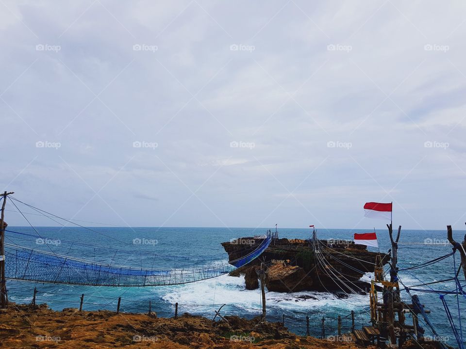 This is Timang Beach, located in Gunung Kidul district, Yogyakarta, Indonesia.

Timang Beach not only presents the beauty of panoramic sea beach south that lies from the top of the cliff wall, but this beach turned out to present an attraction that can spur our adrenaline.

A traditional gondola made of wooden chains and driven by a mechanical system from the mine's tugs will lead us across to the island in the middle of the ocean. The distance is not far, only about 50 meters, but the distance becomes so thrilling when we are already on the Gondola to cross to the next island.

The road to this place.

The rocky and slippery roads require you to be careful. I suggest if you are in doubt it is better to enter by using offroad car. Because the road is quite dangerous. can-can your car tire broke if not careful. I recommend not to use motorcycle matic. But from the difficulty of this field everything will be paid off with a very beautiful and beautiful scenery.