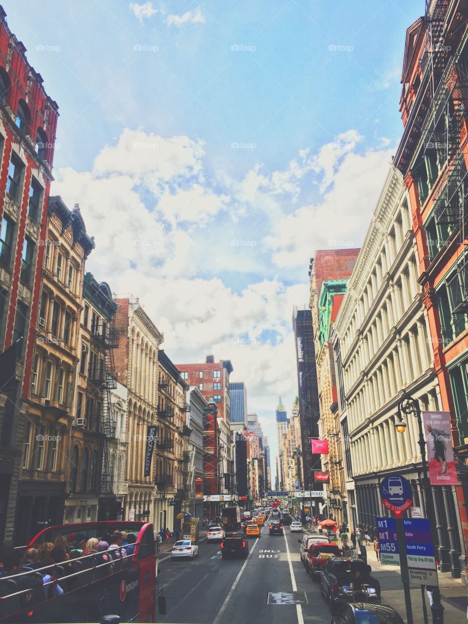 Tour bus views in a bustling, colorful New York street. Surrounded by beautiful old buildings and the warm summer air. 