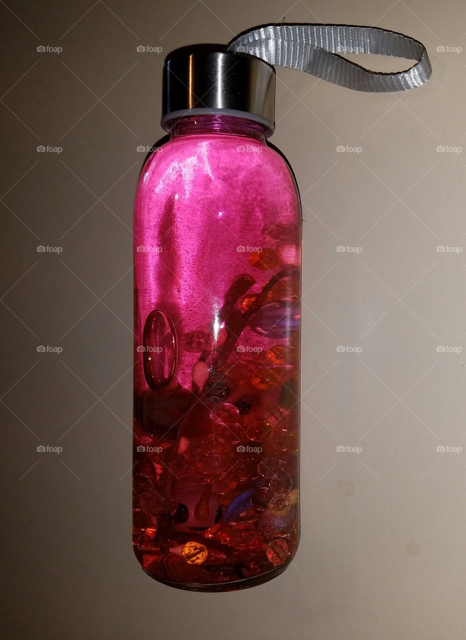 Pink bottle appears to be floating, pretty filling.