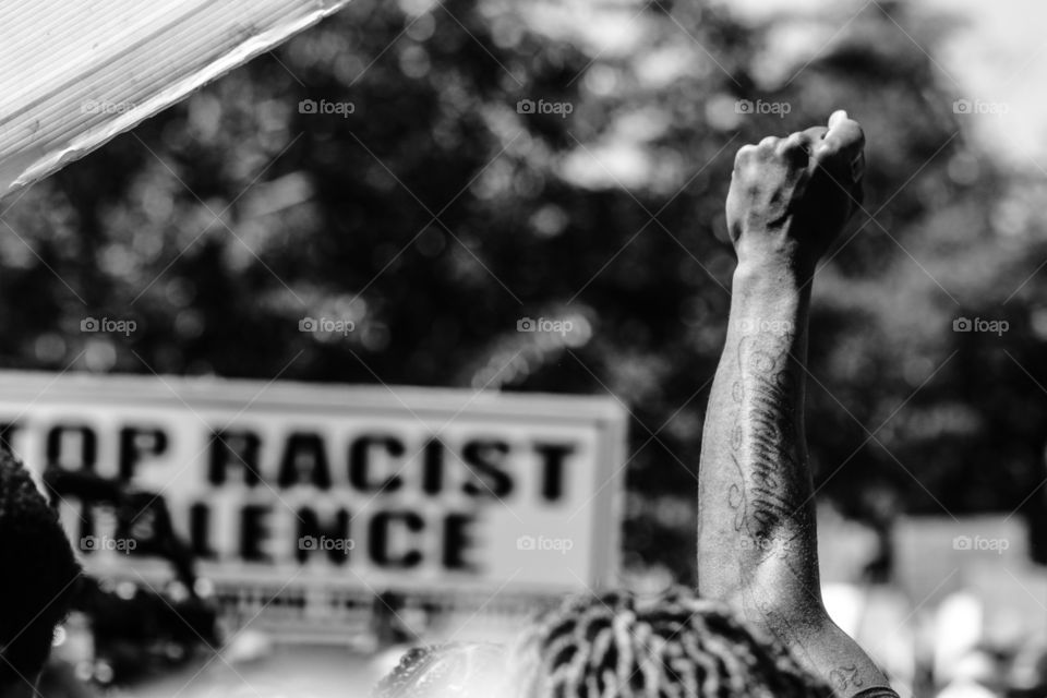 Man holds hand up and shouts, “Black Lives Matter”