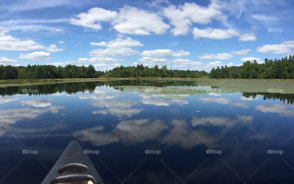 Canoe on a lake reflecting the sky