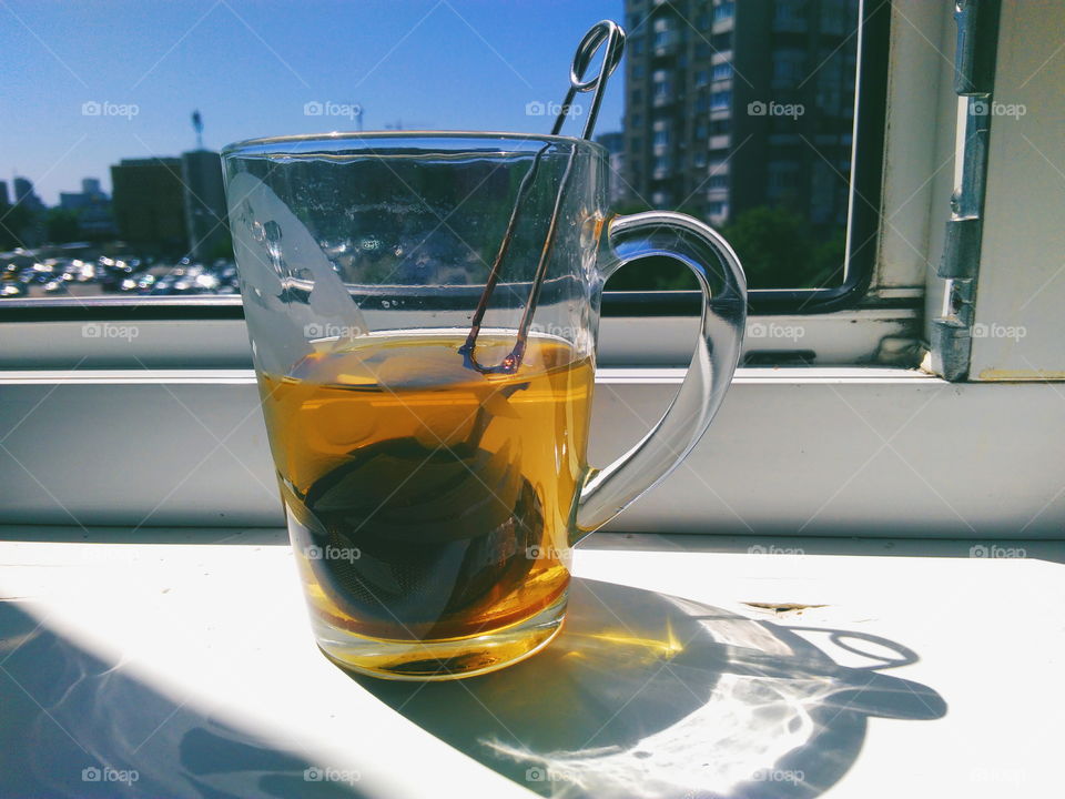 a cup of green tea is on the windowsill