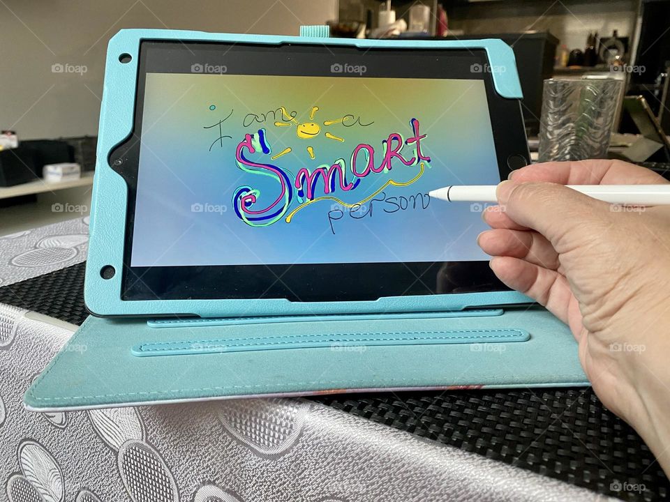 Drawing on iPad. Hand holding iPad drawing pencil 