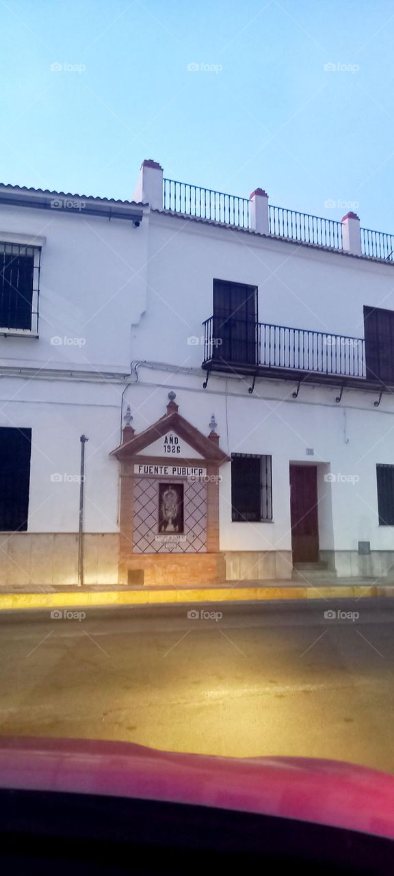 Fuente pública en fachada de casa