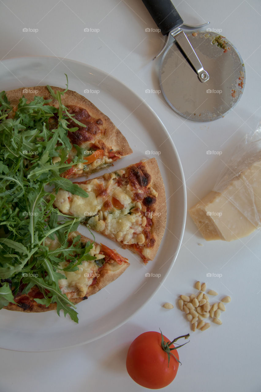 Pizza fresh out of the oven topped with arugula 