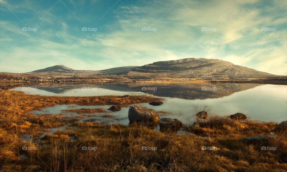 Beautiful morning landscape scenery with mountains reflected in Lake at Burren National Park in county Clare, Ireland