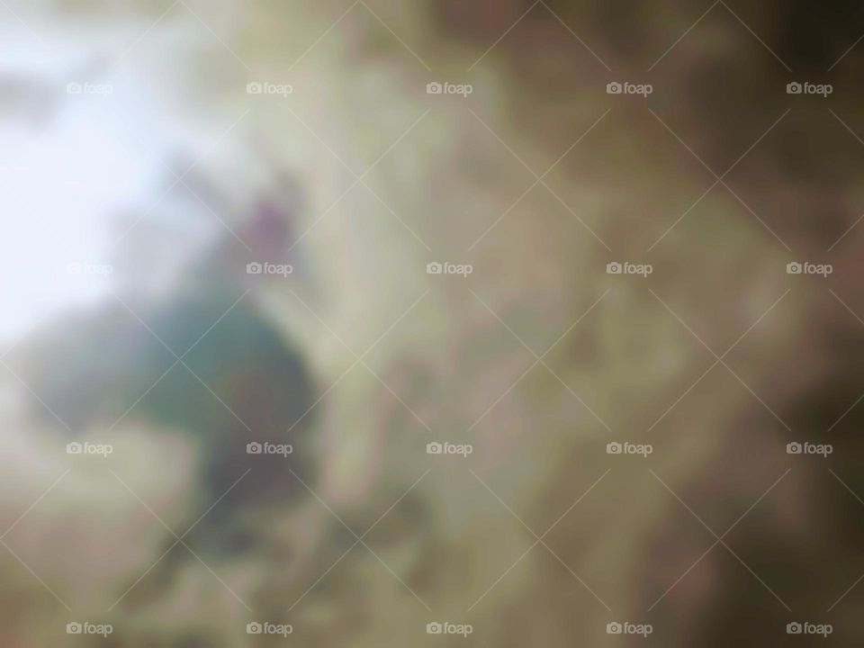 Blurry photo of the sun in the sky at noon