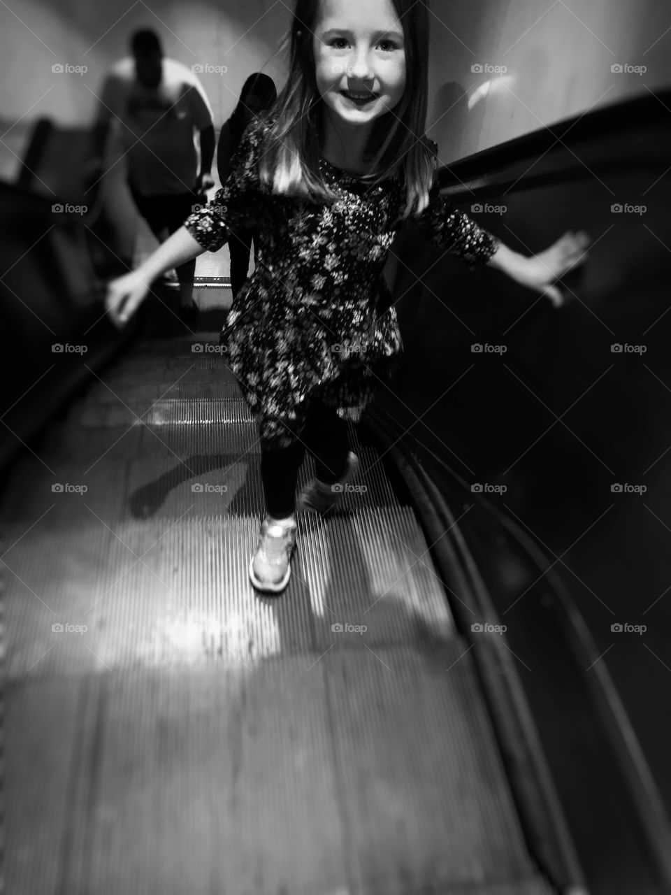 A little girl on escalator in station