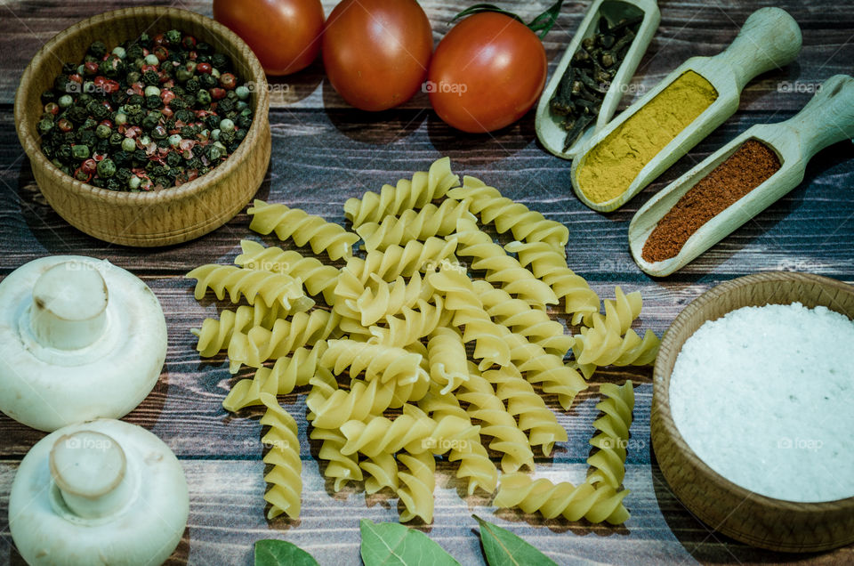 Raw pasta with ingredients and wooden accessories